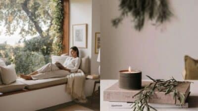 Cozy reading nook with woman relaxing by a window, and a lit candle on books, creating a tranquil atmosphere.