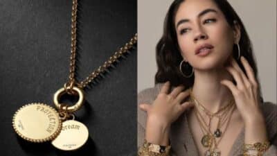 Gold necklaces with engraved pendants; woman wearing layered gold jewelry and rings, posing elegantly.