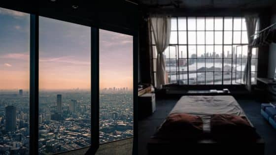 Viewing Deck Blog 2 Cityscape view from high-rise window and cozy bedroom with a large window overlooking an urban skyline at sunset. | Sky Rye Design Cityscape view from high-rise window and cozy bedroom with a large window overlooking an urban skyline at sunset.