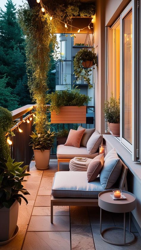 Cozy balcony with seating, hanging lights, and lush plants at dusk, creating a serene outdoor retreat.
