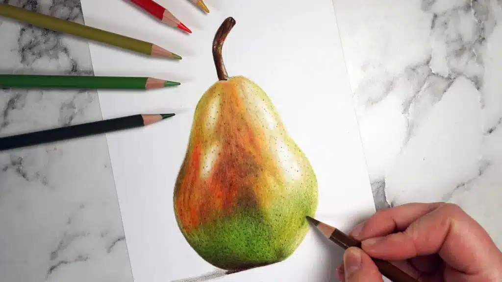 Close-up of a hand drawing a realistic pear with colored pencils on marble surface.