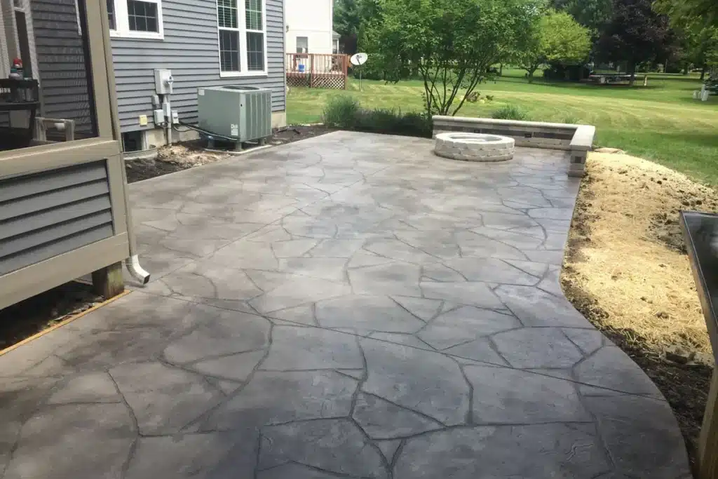 stone-pattern-decorative-concrete-patio Stamped concrete patio with fire pit and garden view in a suburban backyard. | Sky Rye Design Stamped concrete patio with fire pit and garden view in a suburban backyard.