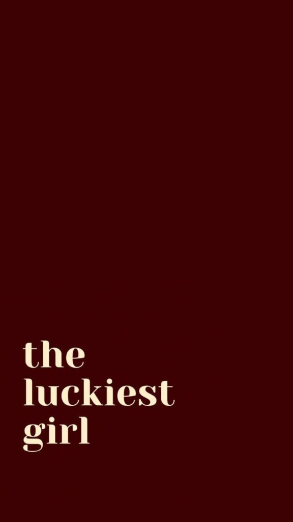 Text the luckiest girl on a dark red background, highlighting optimism and positivity.