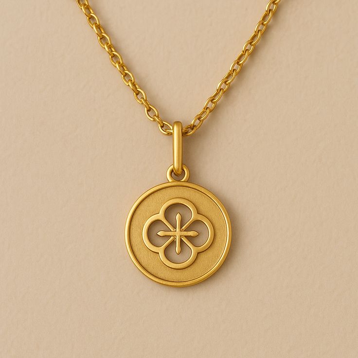 Elegant gold pendant necklace with intricate floral design on beige background.