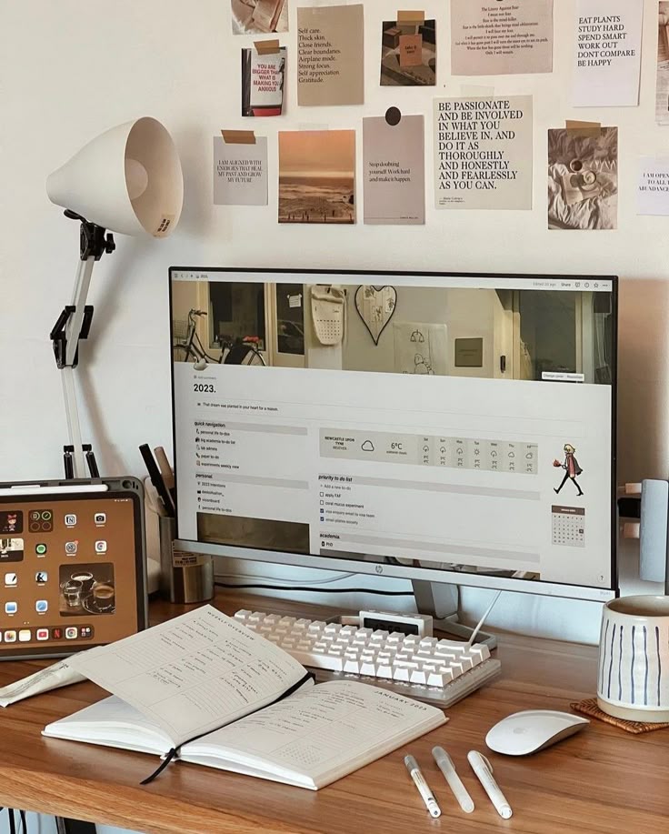 Minimalist home office desk with computer, notebook, wall art, and decor for inspiration and productivity.