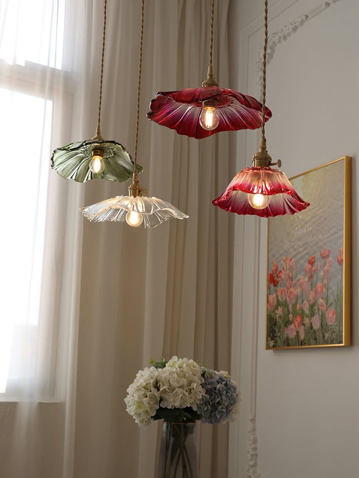 Vintage floral pendant lights in a cozy room with soft curtains, framed art, and a bouquet of hydrangeas.