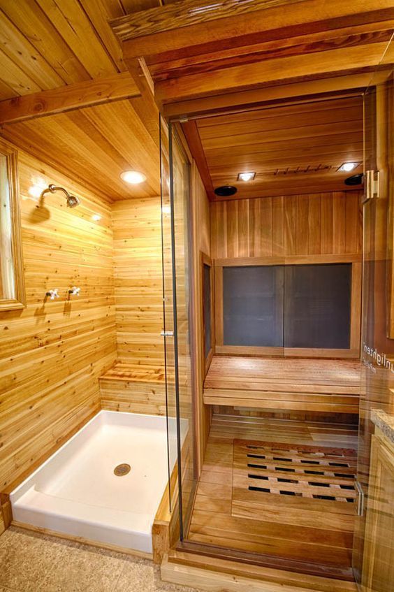 Modern wooden sauna room with glass door and adjacent shower space, providing a relaxing home wellness environment.