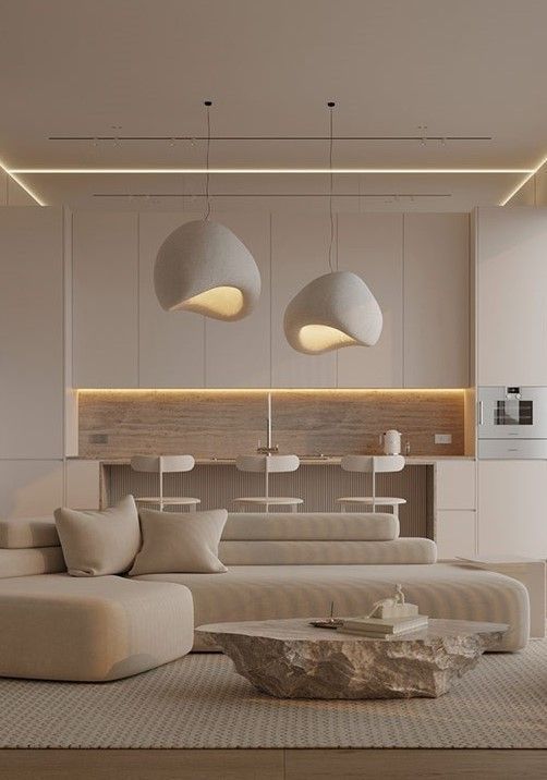 Modern minimalist living room with pendant lights, neutral-toned decor, textured coffee table, and cozy seating.