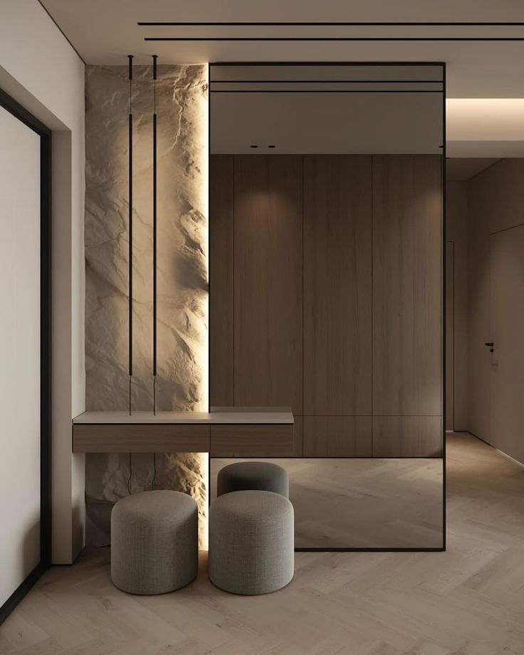 _ 1 Modern interior with textured wall, wooden console, and round poufs. Minimalist hallway with warm lighting. | Sky Rye Design Modern interior with textured wall, wooden console, and round poufs. Minimalist hallway with warm lighting.