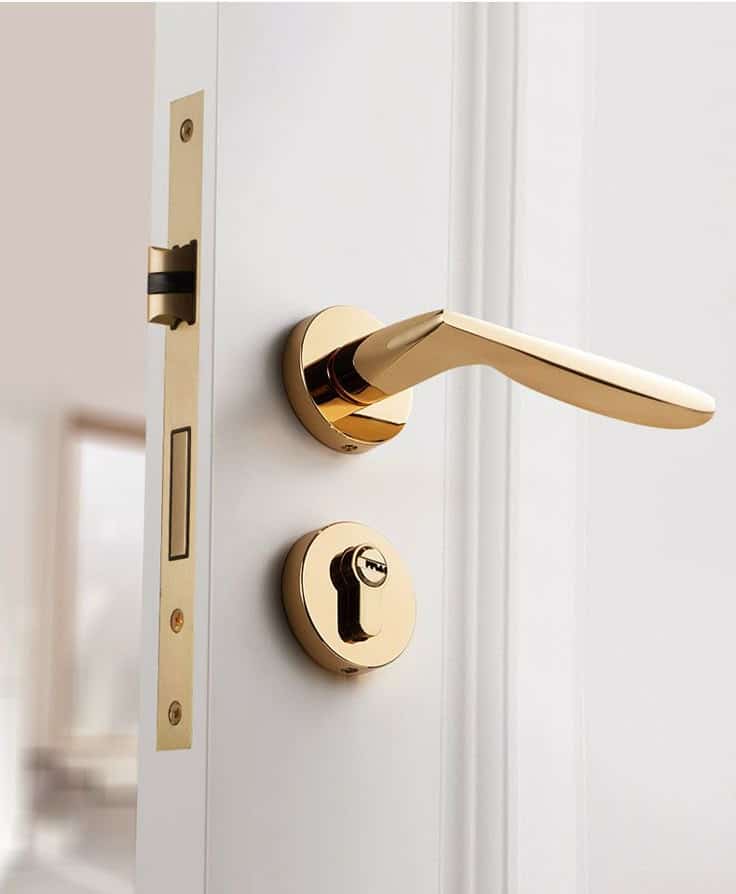 Sleek modern gold door handle and lock on a white door, capturing elegance and contemporary design.