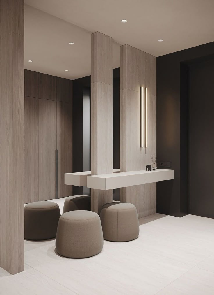 Modern minimalist interior with beige ottomans, wood paneling, and sleek lighting.