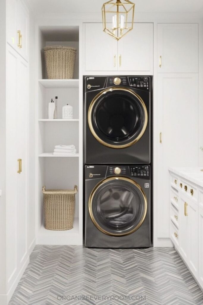 12 Small Laundry Room Organization Ideas to Maximize Space Modern laundry room with stacked black washer and dryer, gold accents, and white cabinetry. | Sky Rye Design Modern laundry room with stacked black washer and dryer, gold accents, and white cabinetry.