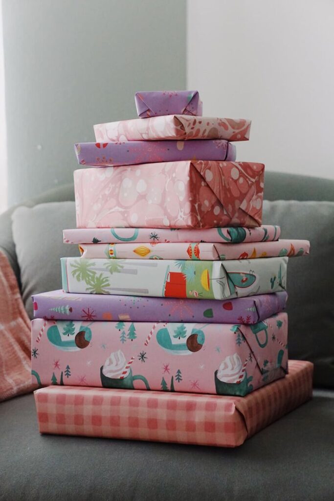 Stack of colorful, beautifully wrapped presents on a couch, perfect for festive celebrations or special occasions.