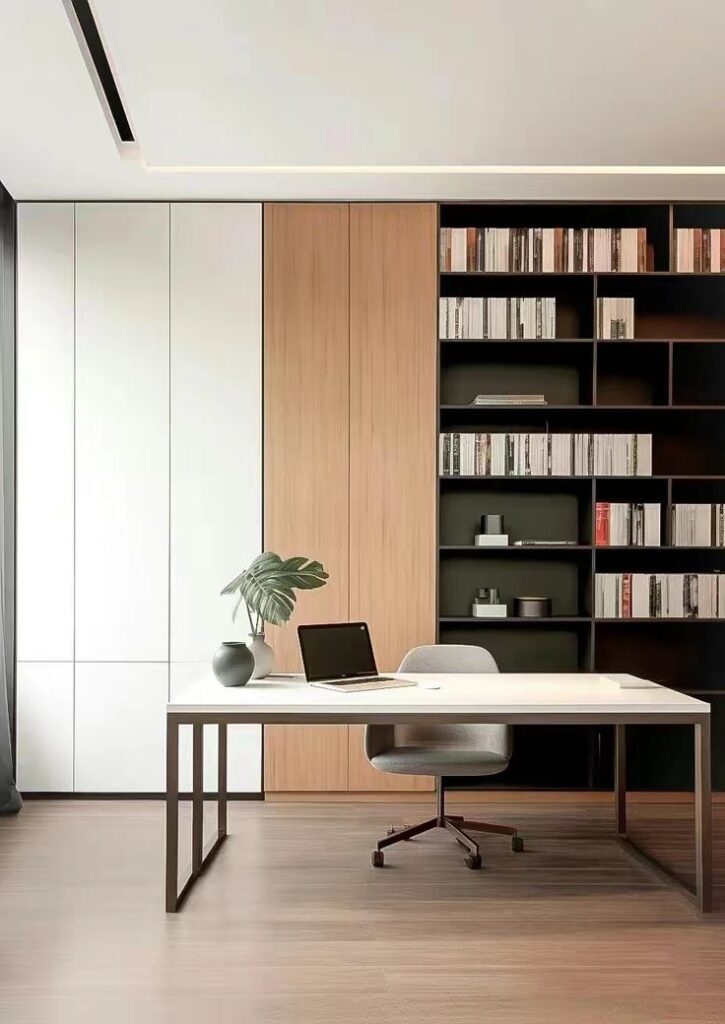 Modern minimalist home office with desk, chair, plant, laptop, and a sleek bookshelf.