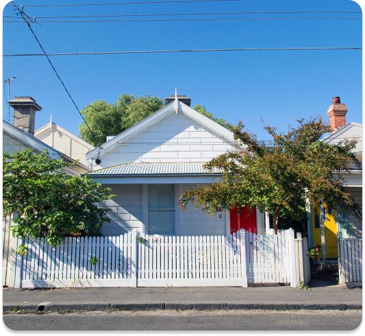 1505156637-BlogHowMillennialsBuyersCompeteHousingMarket-1 Quaint white house with a picket fence and colorful doors under a clear blue sky. | Sky Rye Design Quaint white house with a picket fence and colorful doors under a clear blue sky.