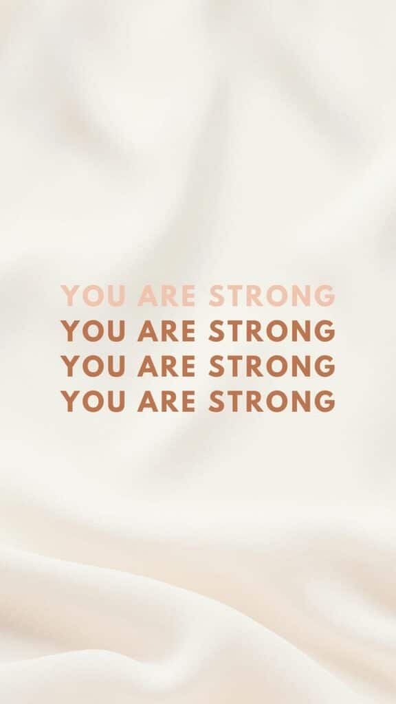 Motivational text on a soft fabric background reading 'You Are Strong' in repeated lines for encouragement and strength.
