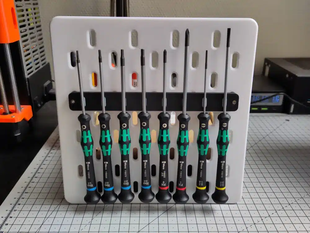 Tool organizer with a set of precision screwdrivers on a perforated board for efficient storage and access.