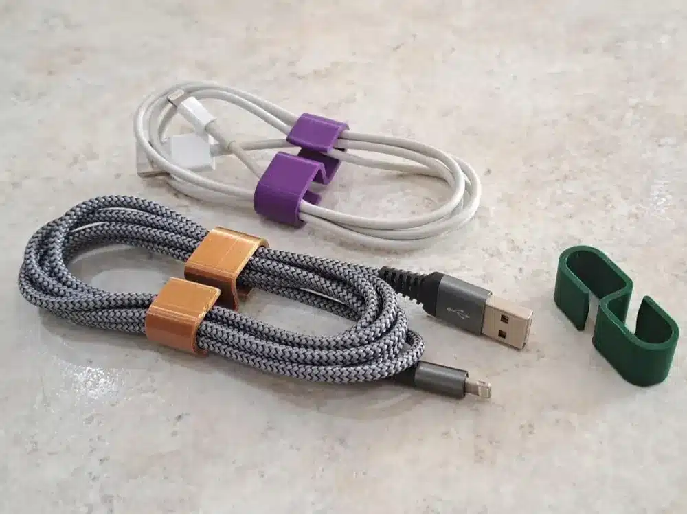 2024-08-05_0616742047517 Organized USB cables with colorful cable clips on a marble surface, featuring braided and white cords for neat storage. | Sky Rye Design Organized USB cables with colorful cable clips on a marble surface, featuring braided and white cords for neat storage.