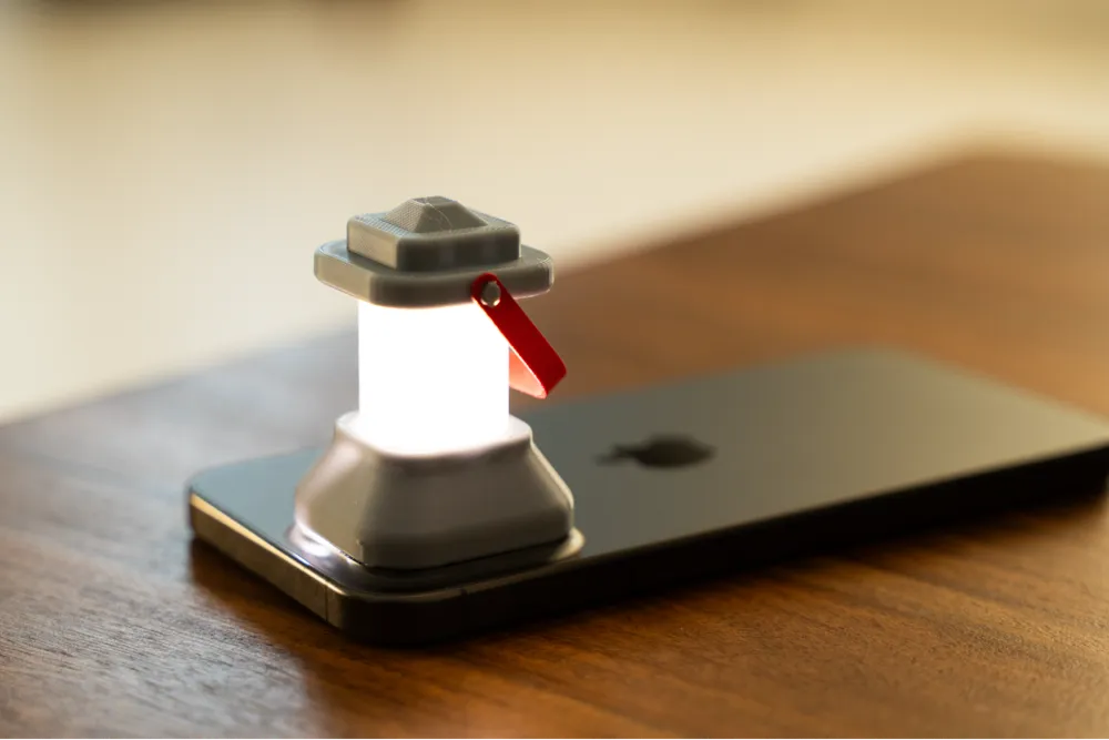 Miniature glowing lantern on a smartphone, placed on a wooden table, creating a cozy ambiance.