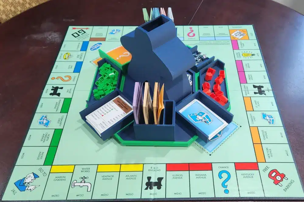 Monopoly board game setup with organized cards and pieces in a custom insert on a wooden table.