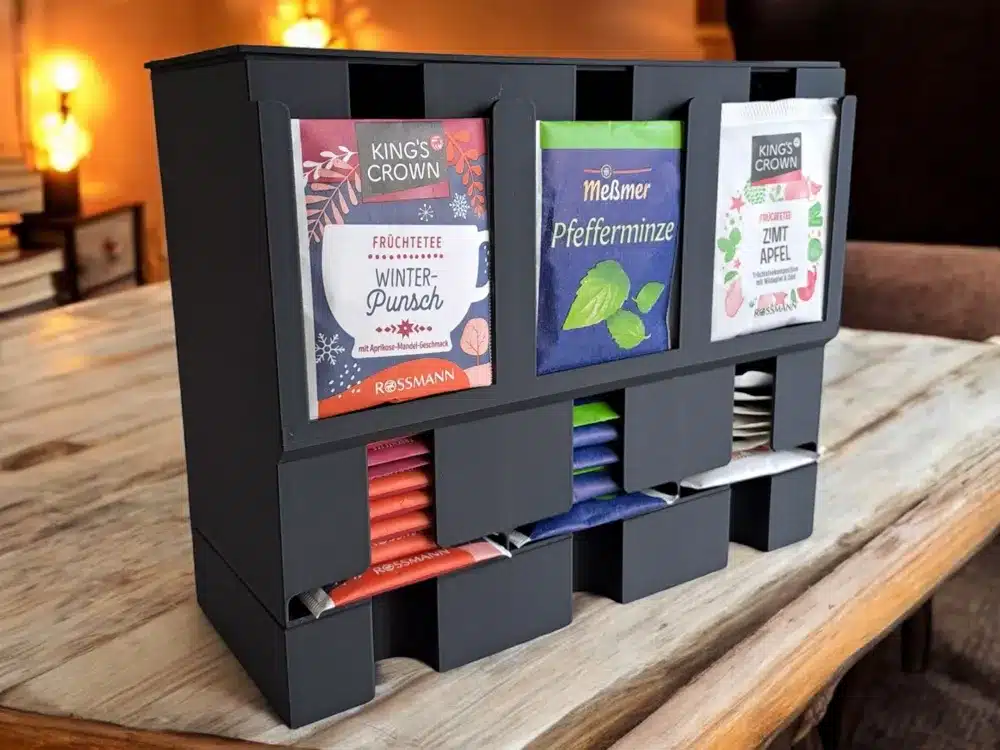 Tea bag organizer on a wooden table, displaying various flavors like winter punch and peppermint tea.