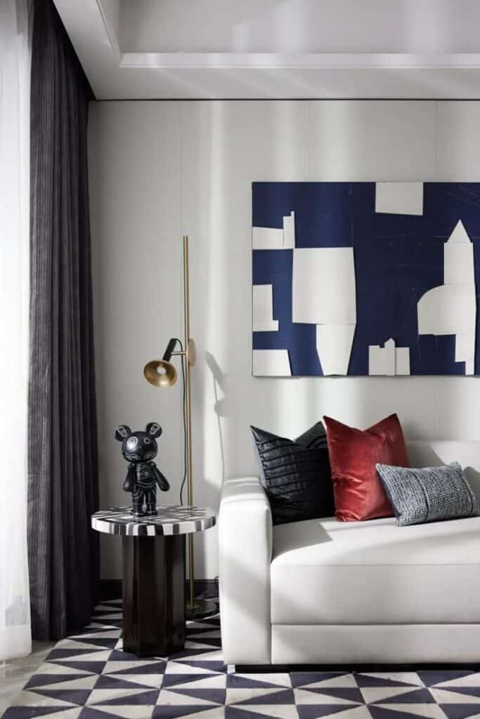 Modern living room with abstract art, geometric rug, white sofa, colored pillows, and a stylish side table with decor. Blue Pantone Style at Home