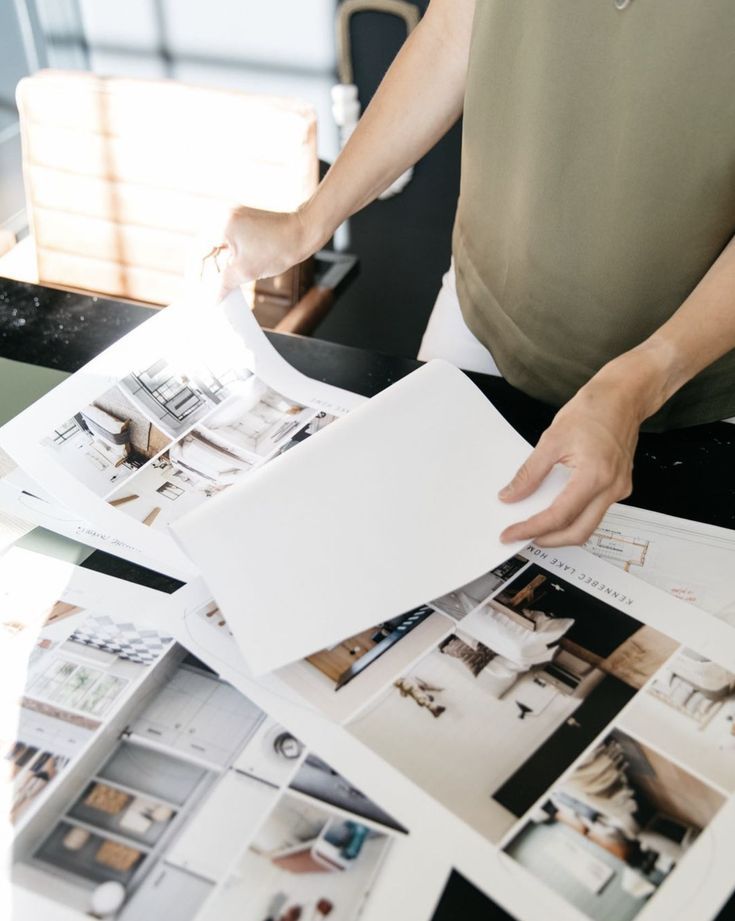 Person reviewing interior design layout pages on a table, showcasing modern home decor ideas.