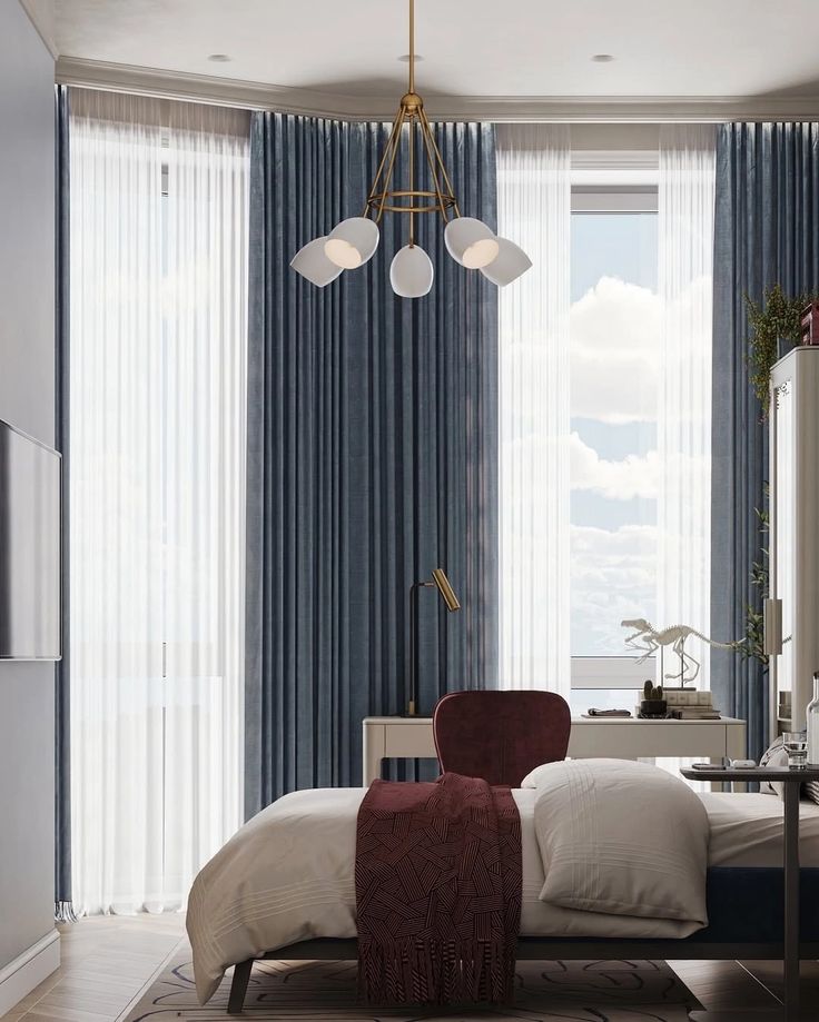 Modern bedroom with blue curtains, cozy bed, red accents, and stylish lighting fixture, creating a serene ambiance.