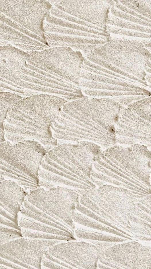 Textured white wall with scallop patterns creating a wave-like effect. Elegant and minimalistic interior design.