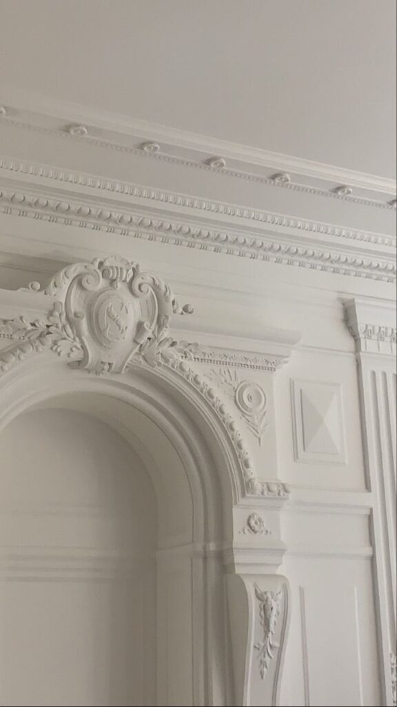 **Alt text:** Elegant white wall with intricate decorative molding and classic architectural details.