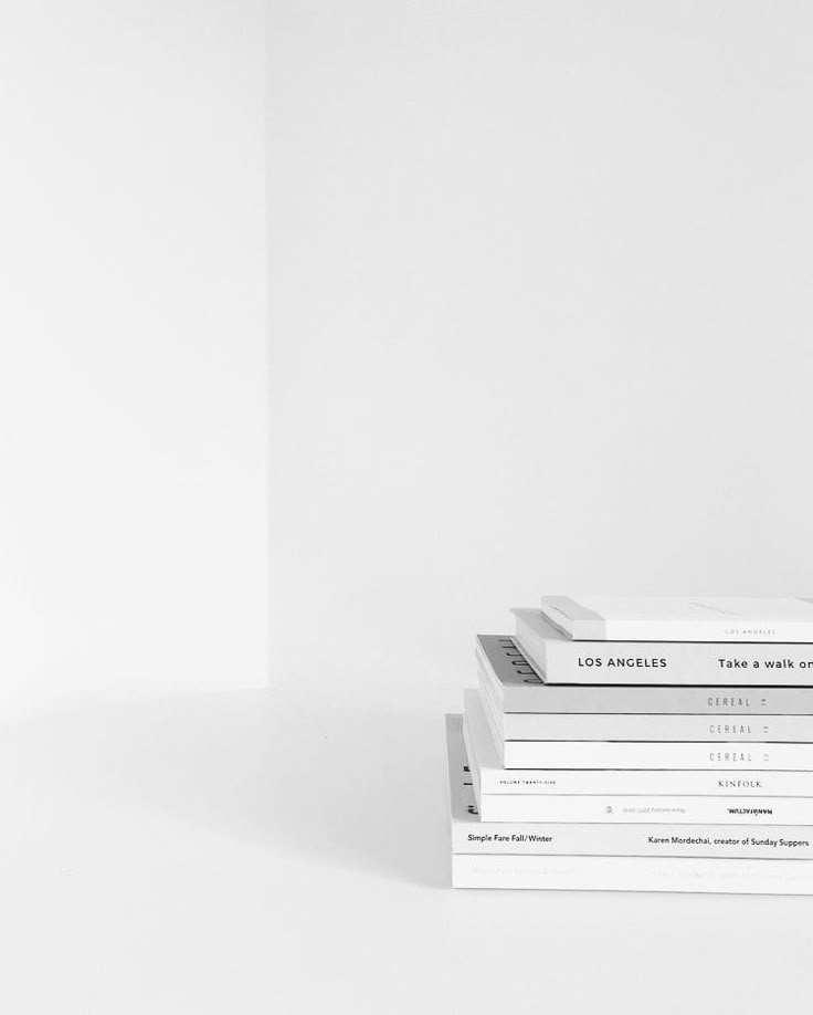 Stack of minimalist white books on a white surface for a clean, modern aesthetic.