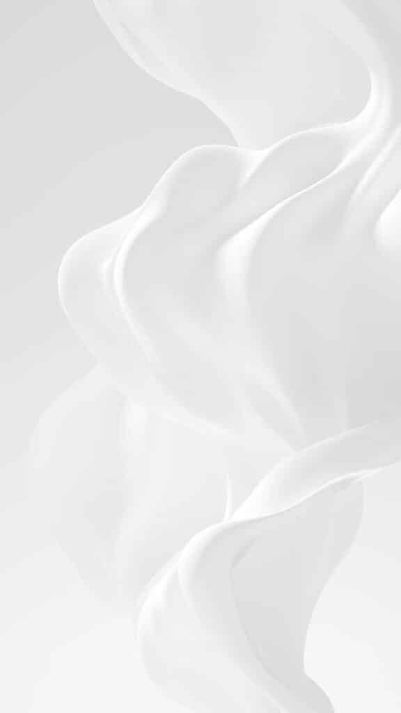 Abstract white flowing fabric against a soft gray background, creating smooth curves and elegant textures.
