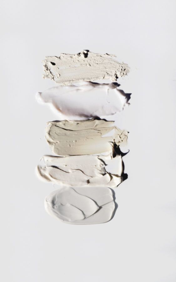 Four textured white paint smears on a white background, showcasing different consistencies and shades.
