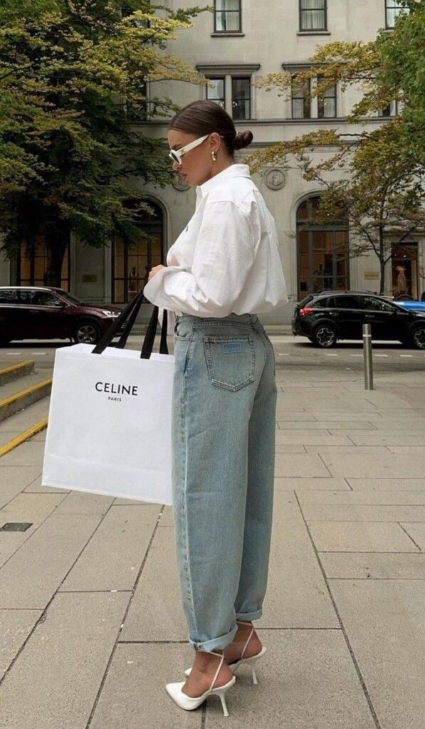 _ - 2025-05-21T104432969 Stylish woman in white blouse and jeans with a Celine shopping bag on a city street. | Sky Rye Design Stylish woman in white blouse and jeans with a Celine shopping bag on a city street.