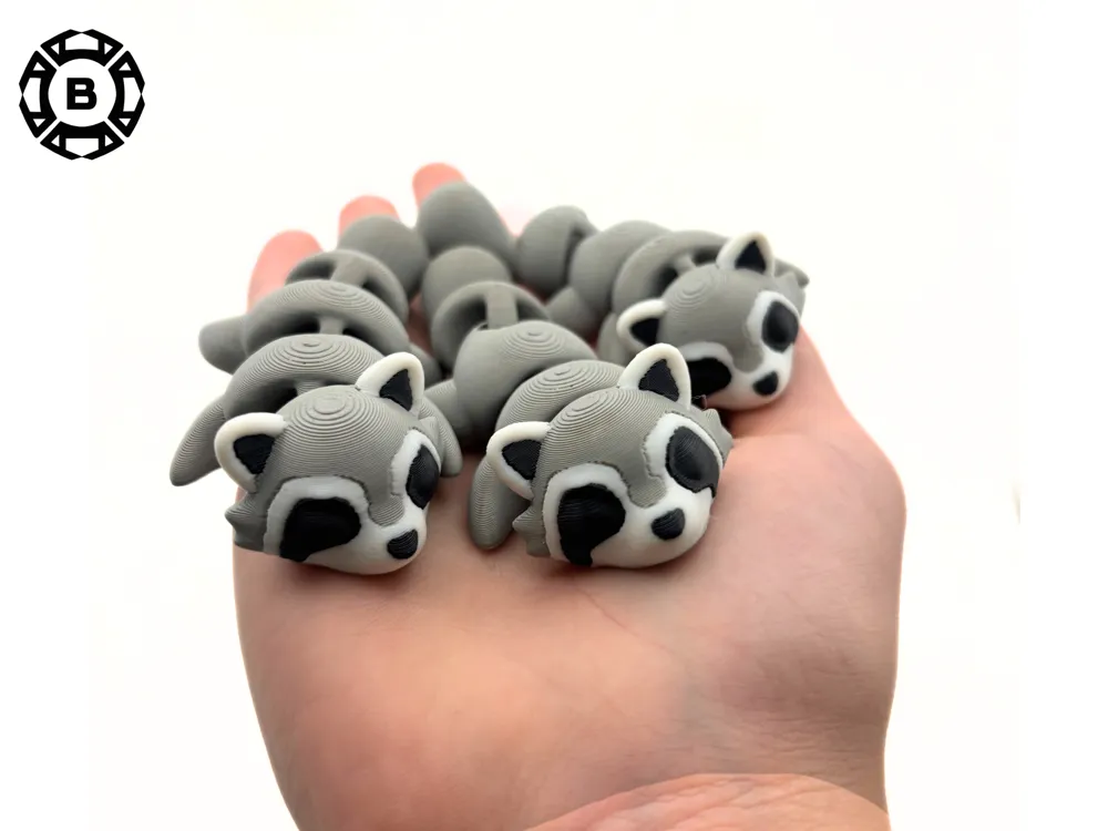 Hand holding small gray raccoon figures, lined up and resting, against a white background.
