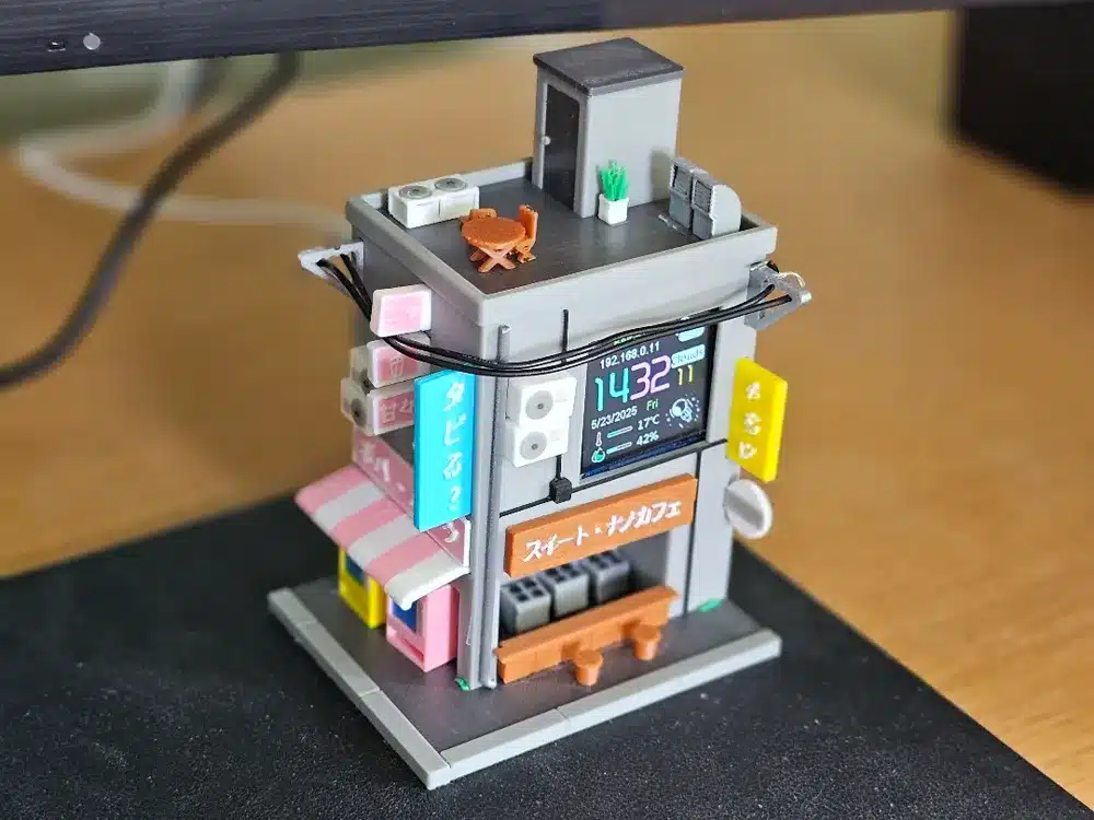 Miniature building diorama with rooftop details and digital display, showcasing Japanese architecture and urban design.