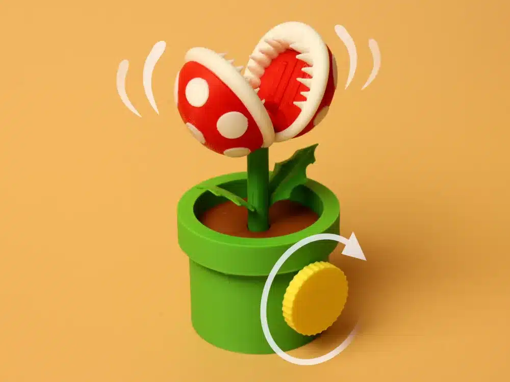 Red and white spotted piranha plant toy in a green pot with a yellow wind-up key against an orange background.