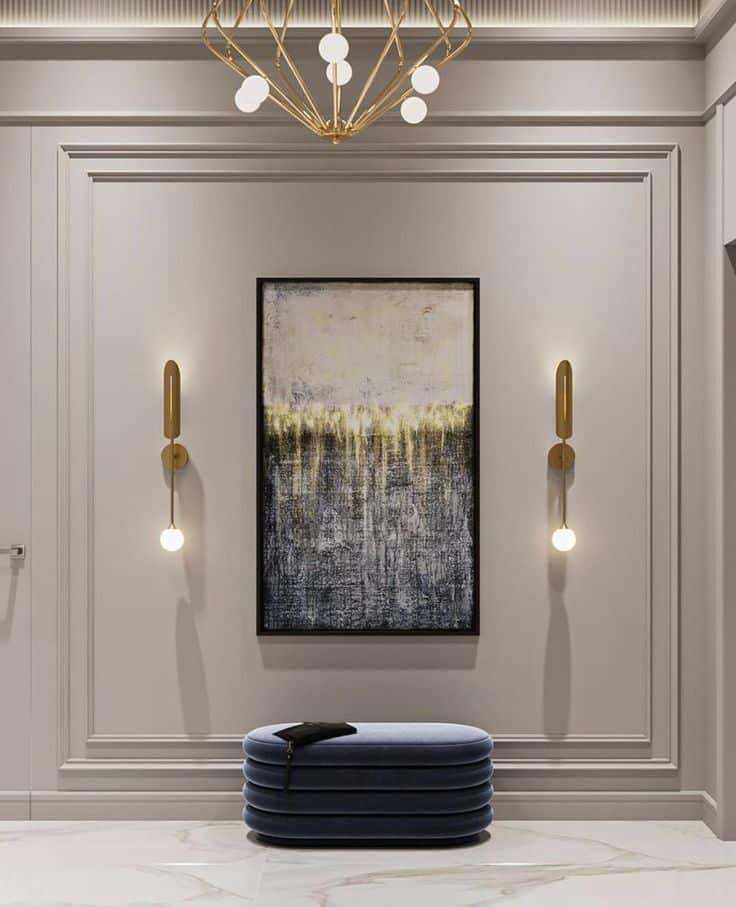 Modern hallway with abstract painting, chic lighting, and stylish blue bench on marble floor.