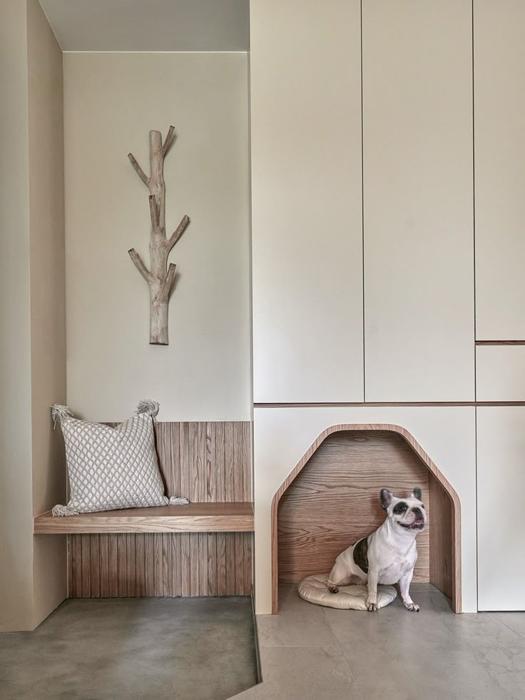 Minimalist dog-friendly interior with a cozy wooden nook and decorative wall piece.