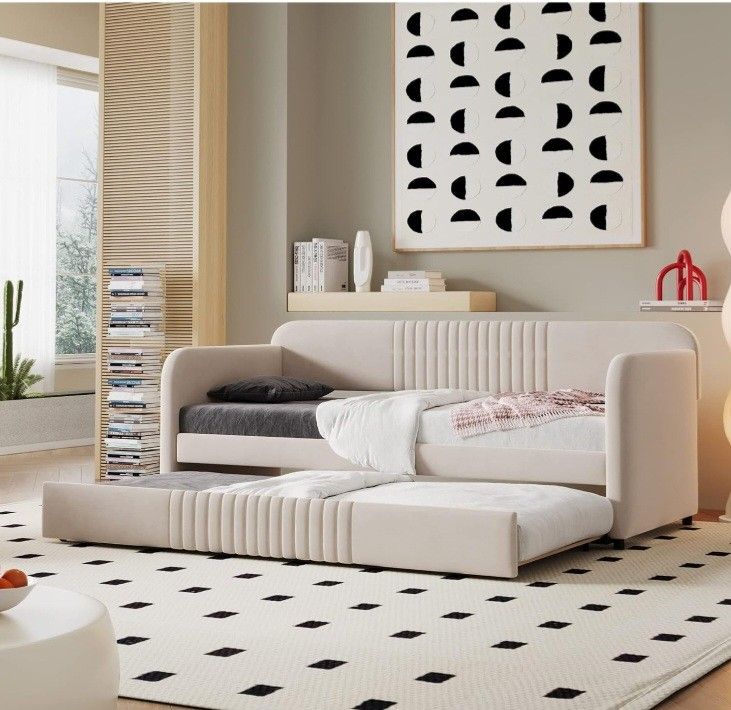 Modern living room with beige pull-out sofa bed, geometric art, and minimal decor. Cozy and stylish interior design.
