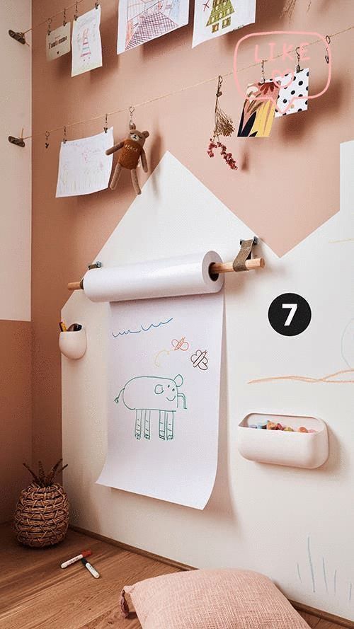Kids' art corner with drawings on display, paper roll for sketching, and pastel-themed decor.
