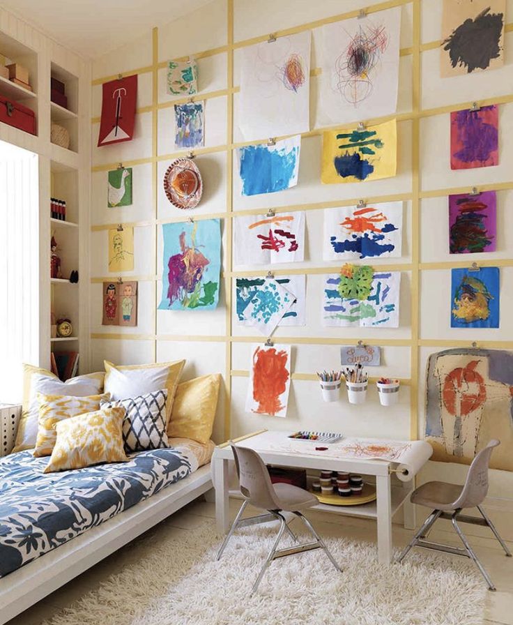 Cozy kids’ room with art-covered wall, playful bedding, and a small art desk, fostering creativity and comfort.