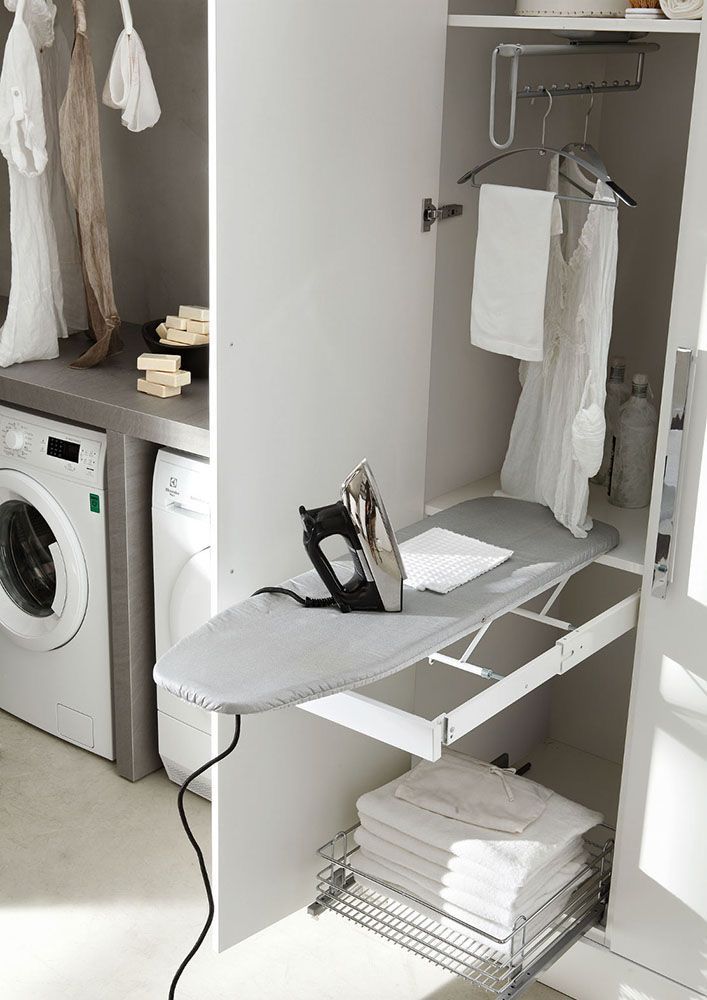 Modern laundry room with fold-out ironing board, washing machine, and hanging clothes storage.