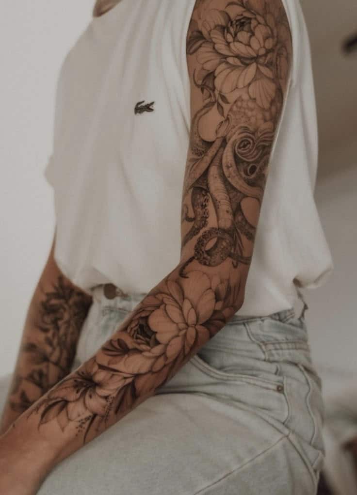 Screenshot Person with detailed floral and octopus sleeve tattoo wearing a white shirt and jeans. | Sky Rye Design Person with detailed floral and octopus sleeve tattoo wearing a white shirt and jeans.