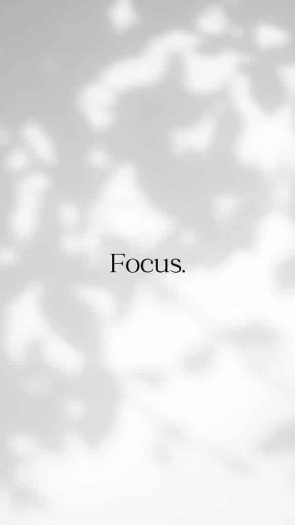 Focus text on blurred gray background with abstract leaf shadows, conveying concentration and mindfulness.