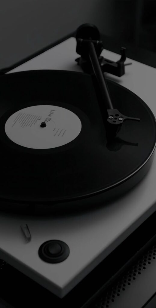 Turntable playing black vinyl record with white label, showcasing classic retro music experience.