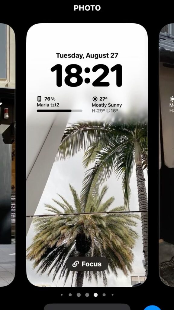 Smartphone screen showing date, time 18:21, weather 27°C mostly sunny, palm trees in background, focus mode.