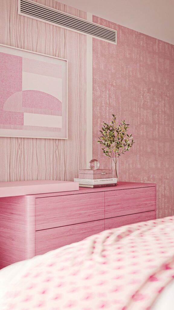 Pink bedroom interior with patterned walls, dresser, framed art, and plant decor. Cozy and modern aesthetic.