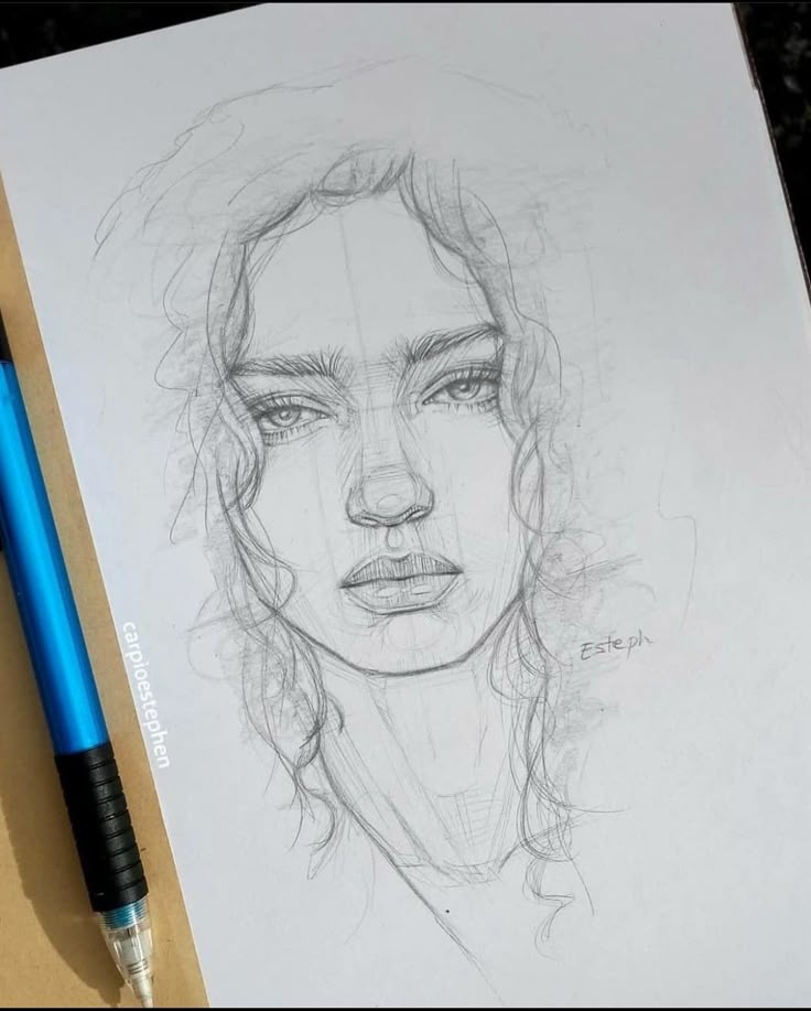 Pencil sketch of a woman's face with curly hair, next to a blue mechanical pencil on paper.