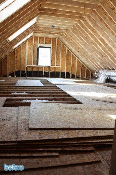 Unfinished attic renovation with exposed wooden beams and floor panels, preparing for insulation and drywall.